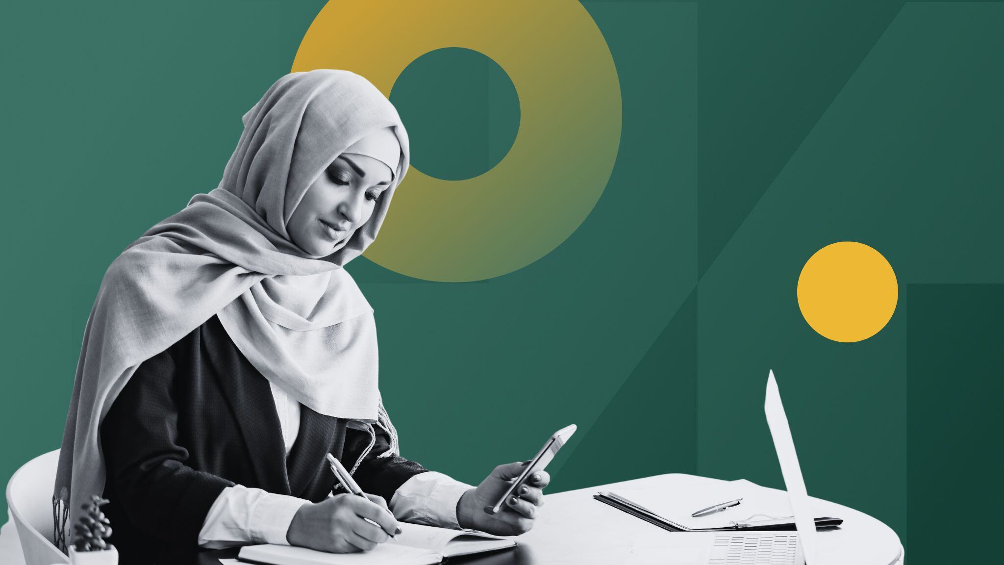 woman-at-desk-holding-phone-and-writing-in-notebook